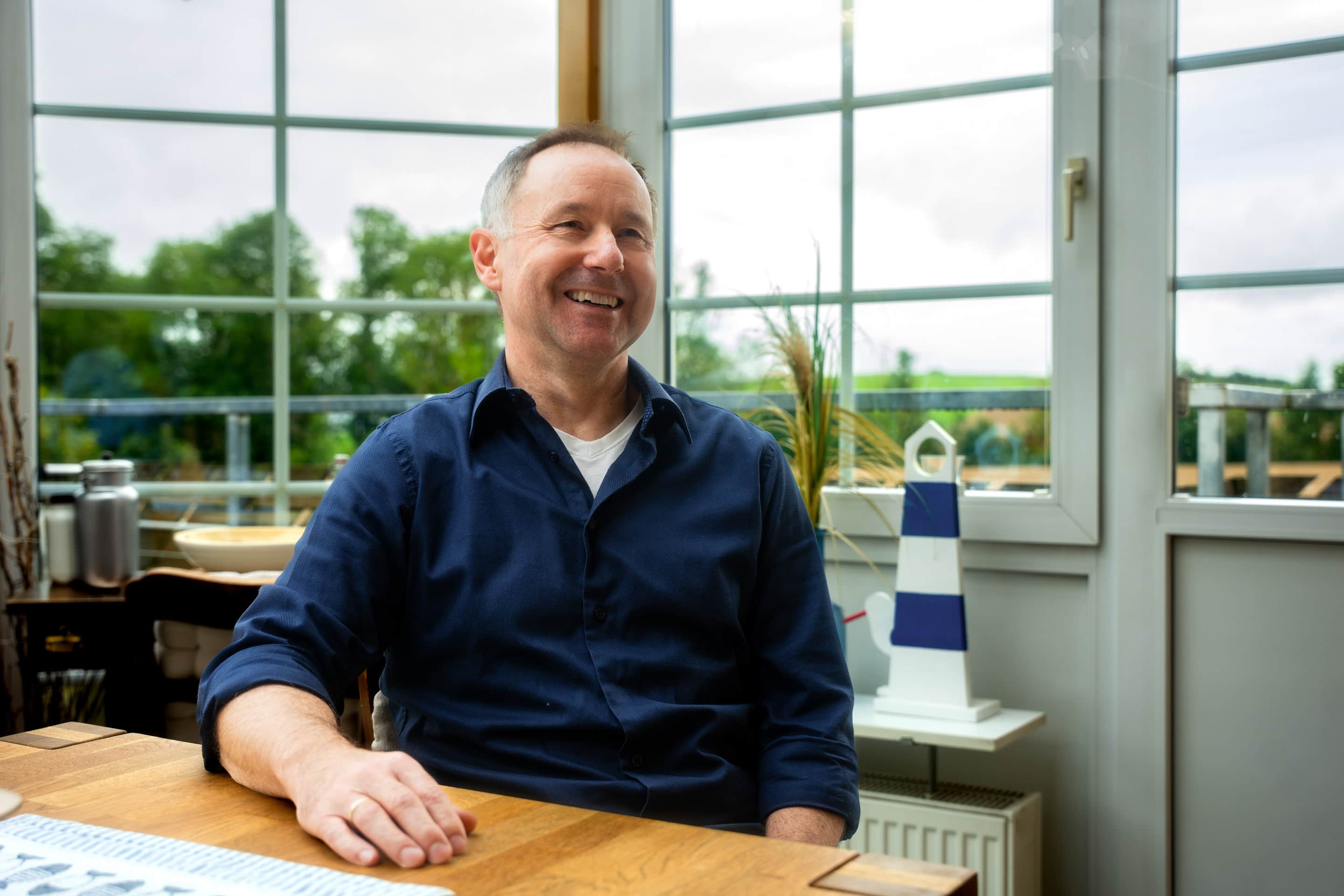 Carsten Klinge sitzt am Tisch und spricht über Wärmepumpen